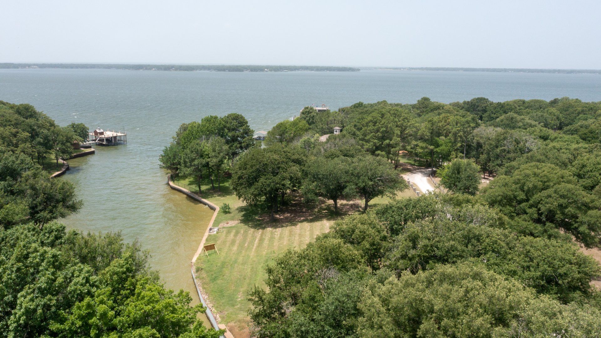 An aerial view of a lake surrounded by trees and grass