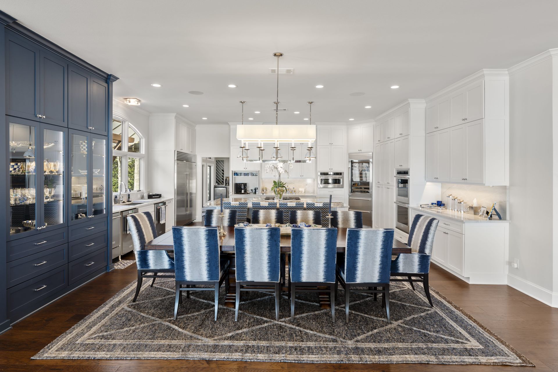 A dining room with a table and chairs and a rug.