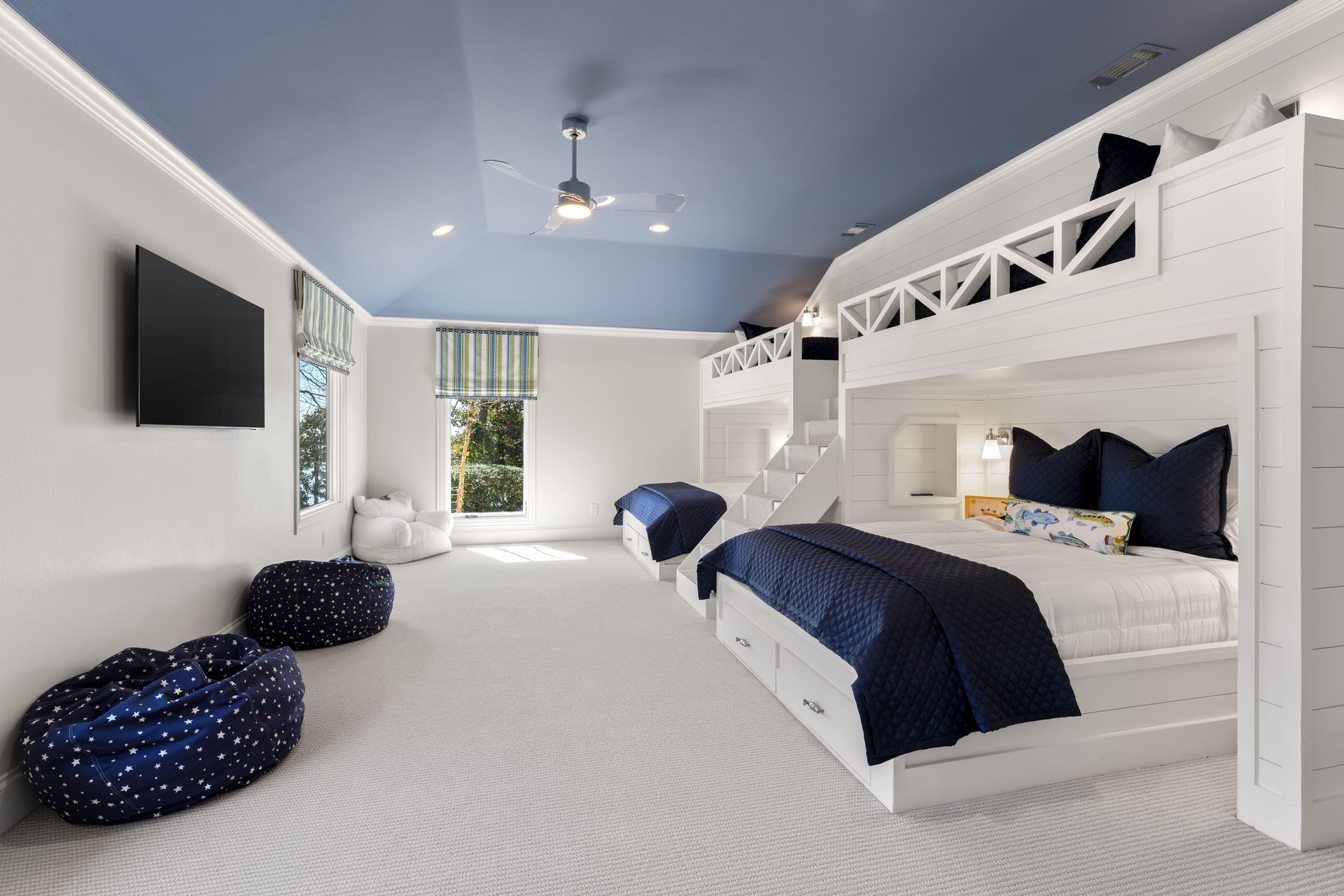 A bedroom with bunk beds and a television on the wall.