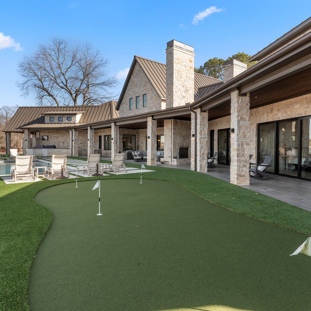A large house with a putting green in front of it