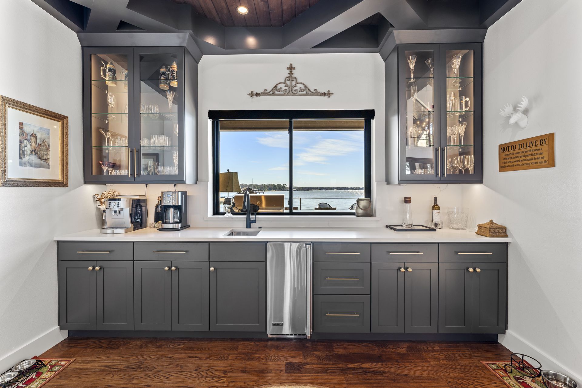 A kitchen with gray cabinets and a large window