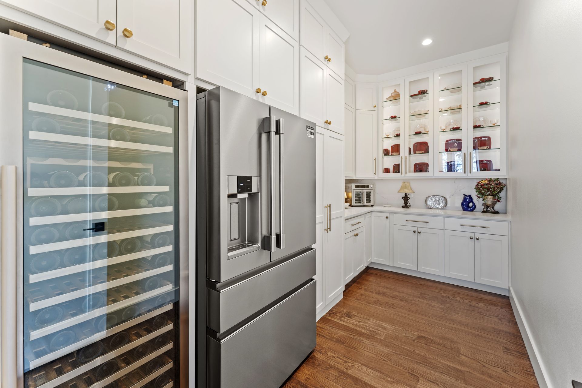 A kitchen with a refrigerator and a wine cooler.