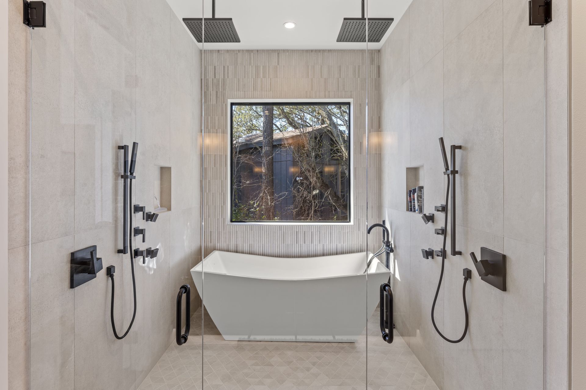 A bathroom with a tub , shower , and window.