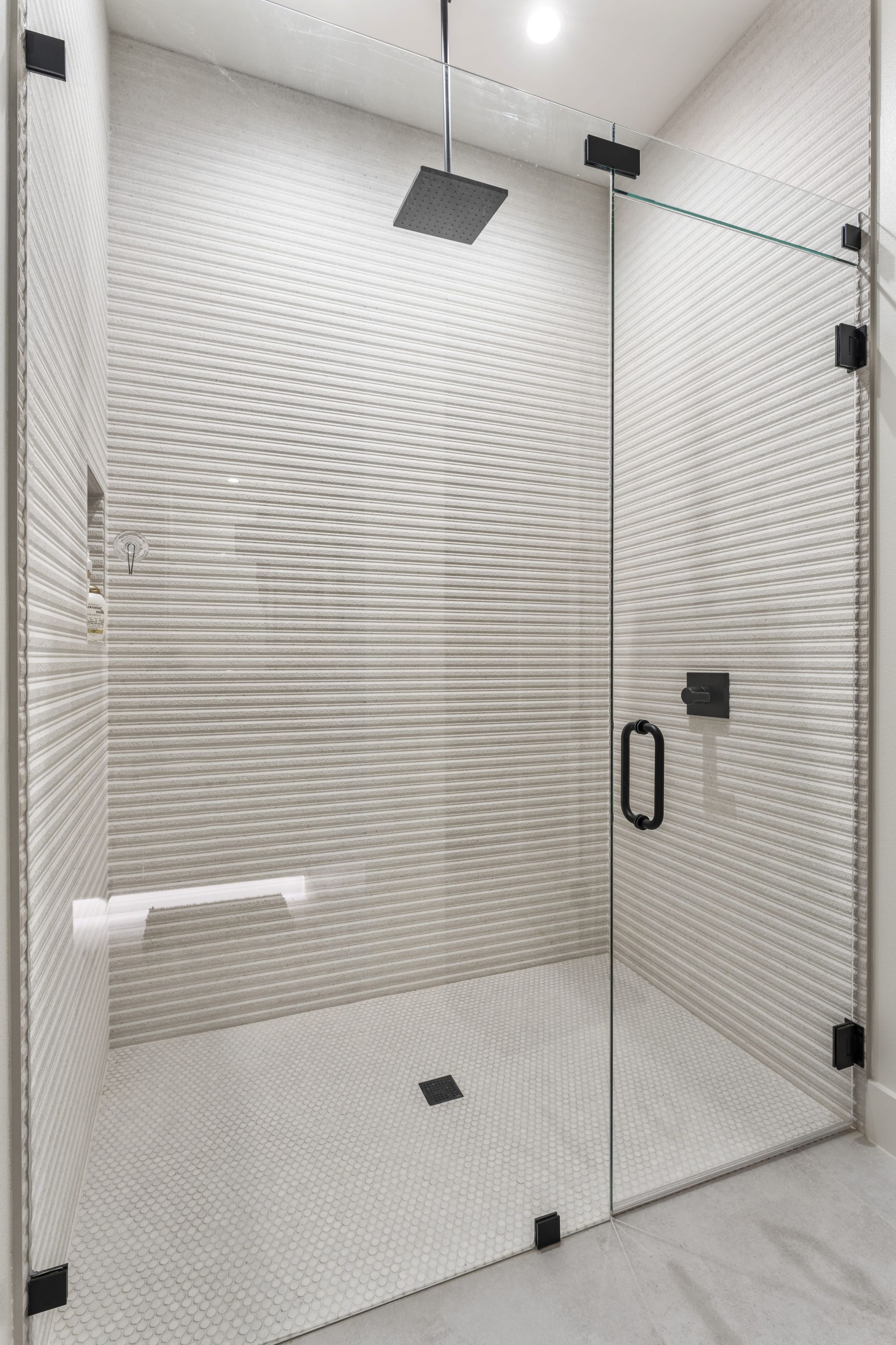 A walk in shower with a glass door and a shower head.