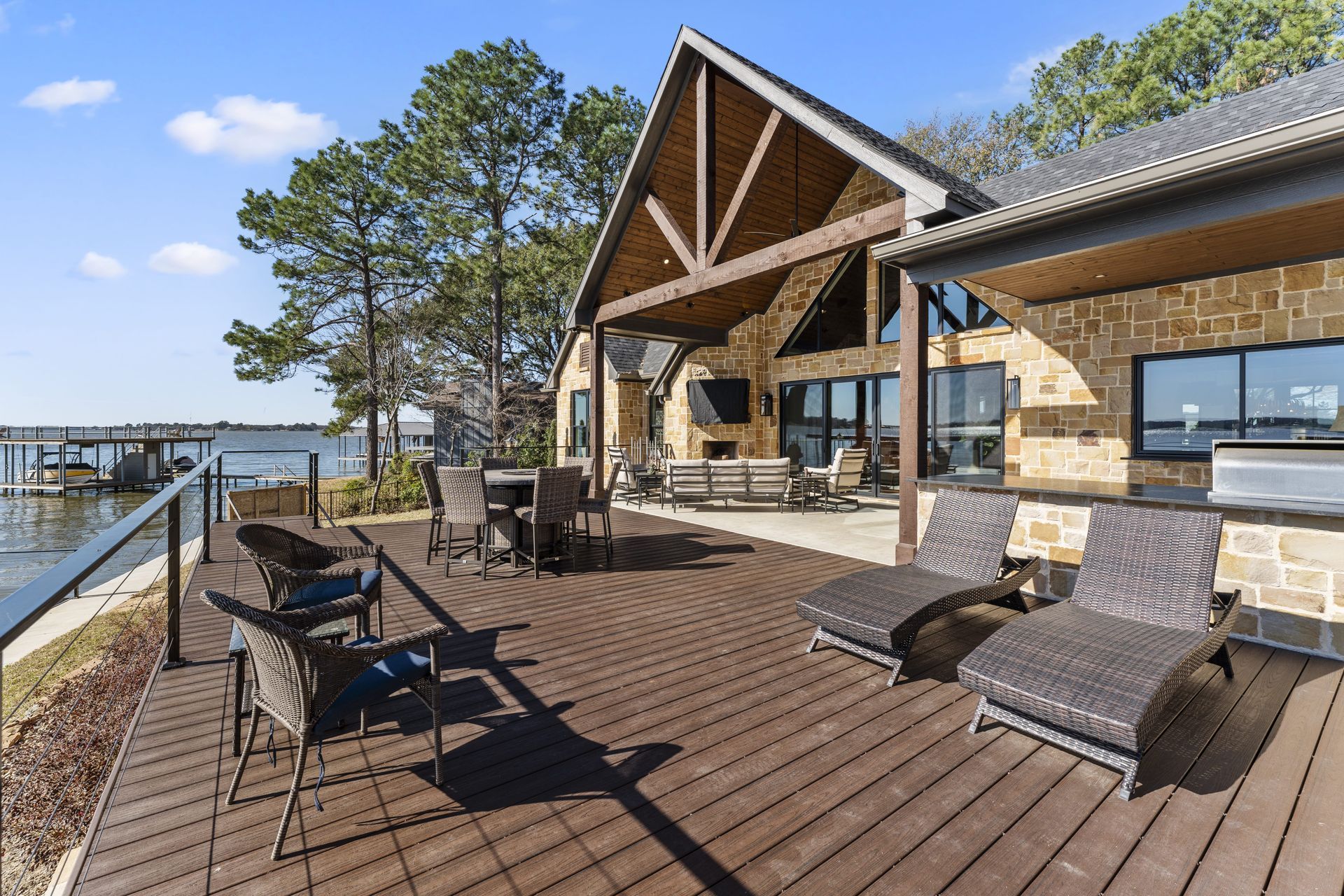 A large house with a large deck overlooking a body of water.