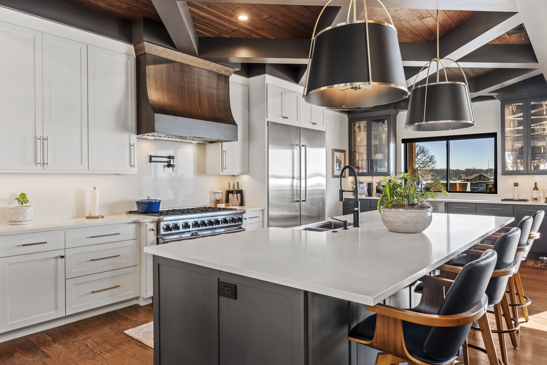 A kitchen with white cabinets , stainless steel appliances , and a large island.
