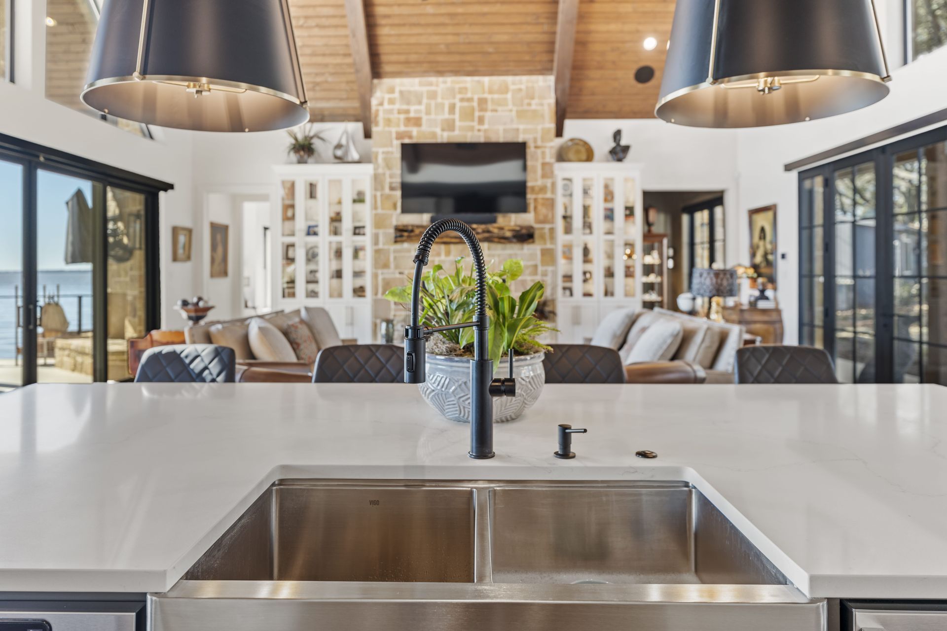A kitchen with a sink and a living room in the background.