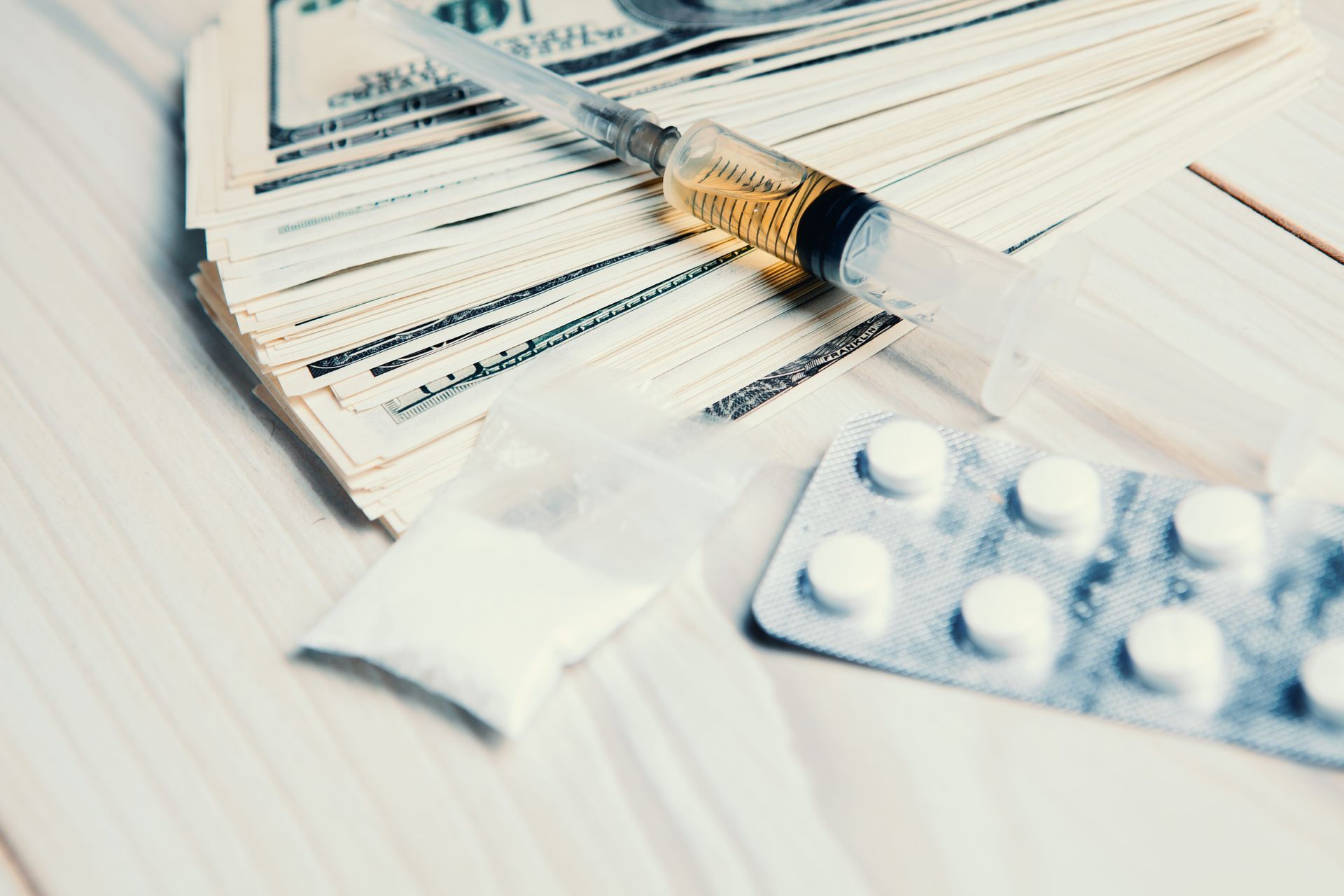 Stack of medicine prescriptions with a pill bottle and blister pack on a white table