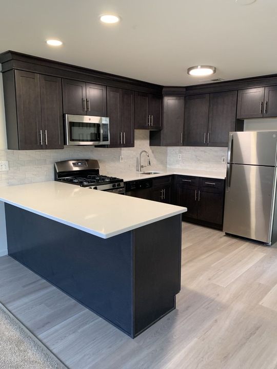A kitchen with stainless steel appliances and black cabinets
