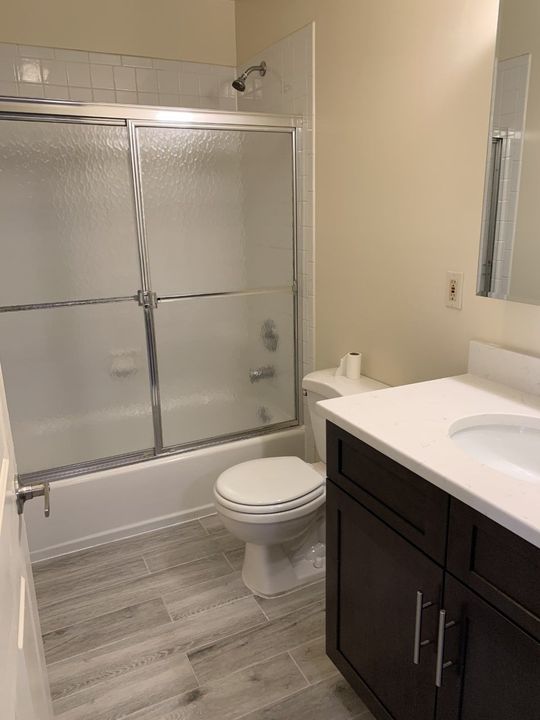 A bathroom with a toilet , sink , shower and bathtub.