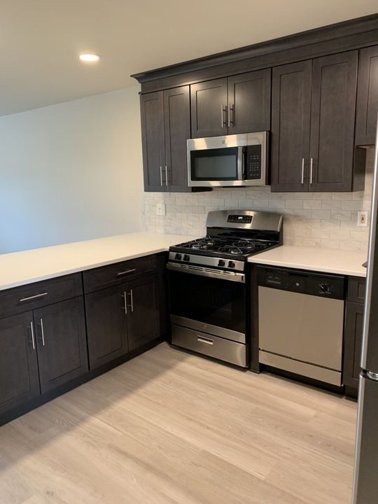 A kitchen with a stove , microwave , refrigerator and dishwasher.