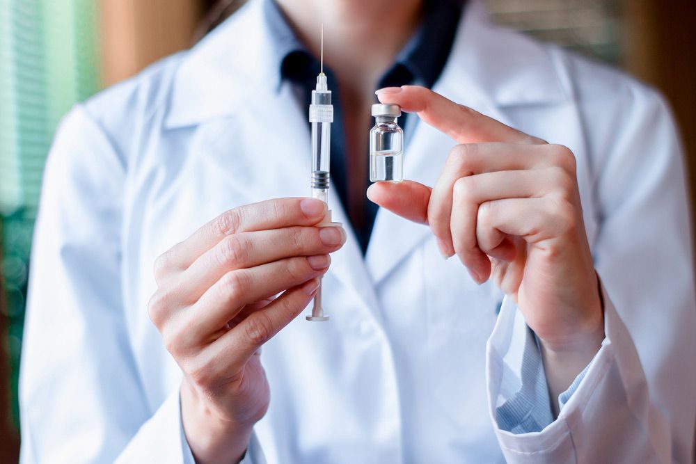A Doctor is Holding Two Syringes in Her Hands — Mount Archer Medical Centre in Berserker, QLD