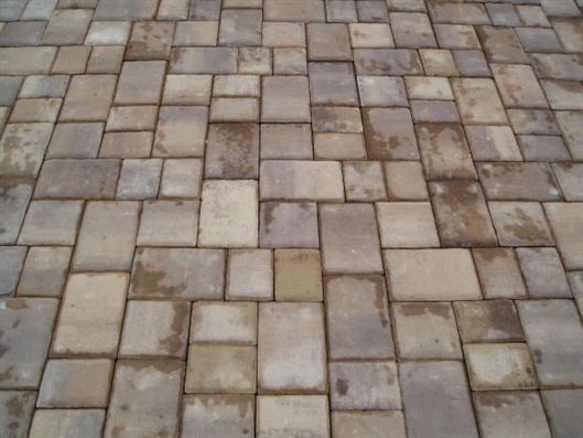Stone-paved walkway with square and rectangular gray-beige tiles