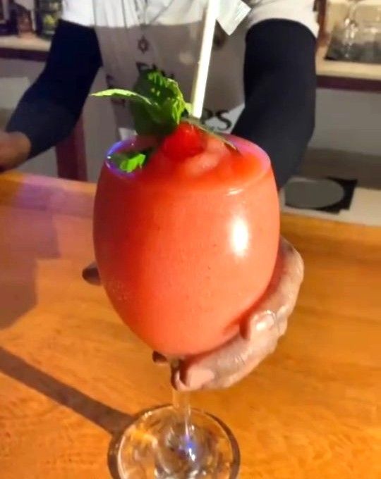 A person is holding a slushy drink with a straw  at V lounge Restaurant inside Villa copthall. 