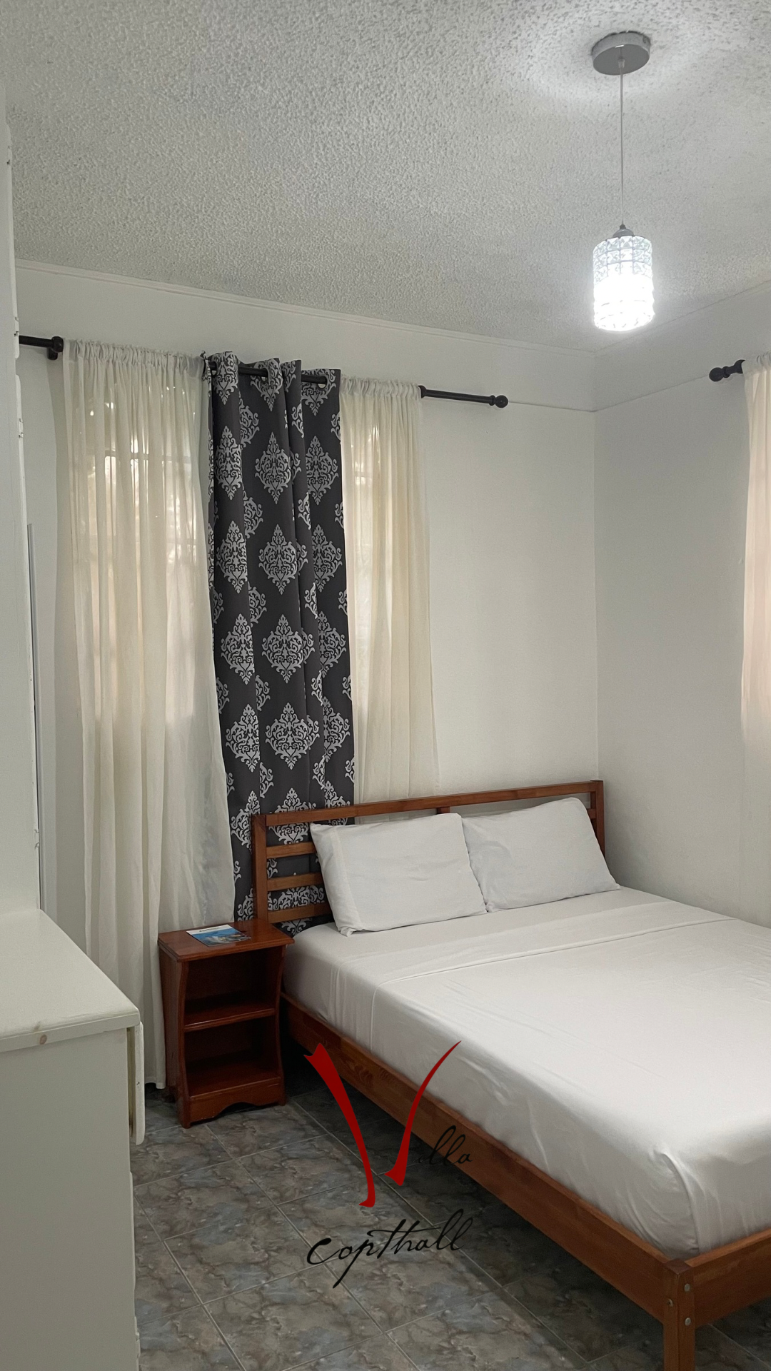 A bedroom with a bed , nightstand , and window.