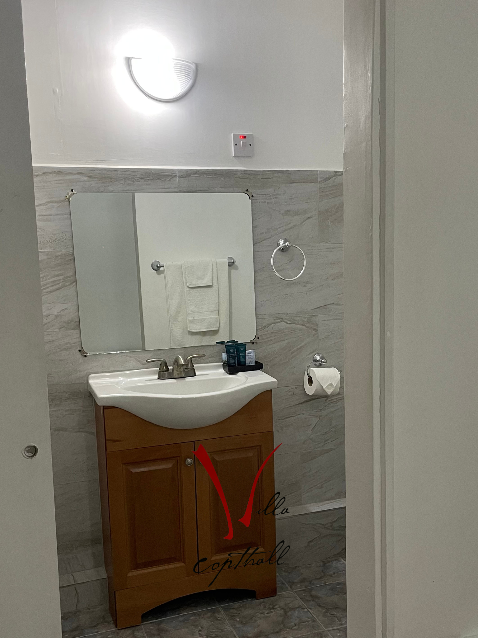 A bathroom with a sink , mirror and towel rack.