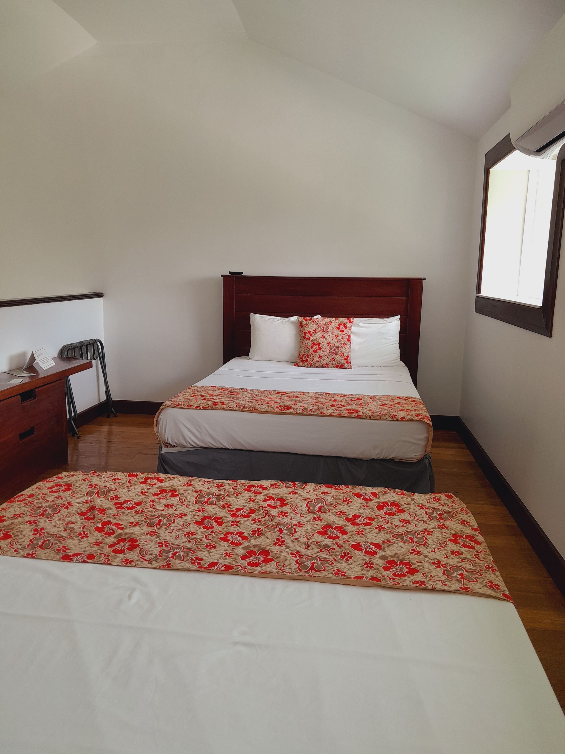 A bedroom with two beds and a window.