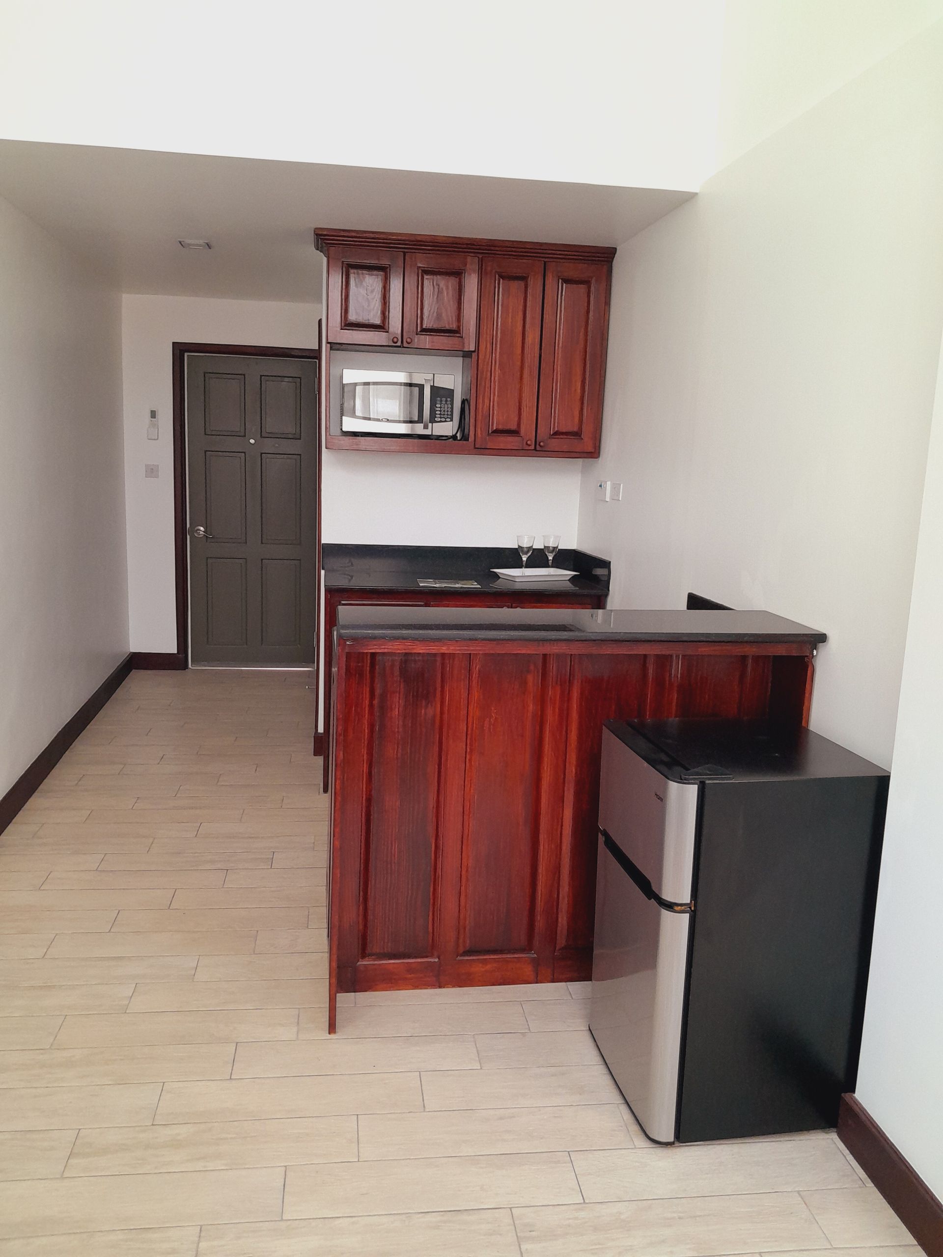 A kitchen with wooden cabinets and a stainless steel refrigerator