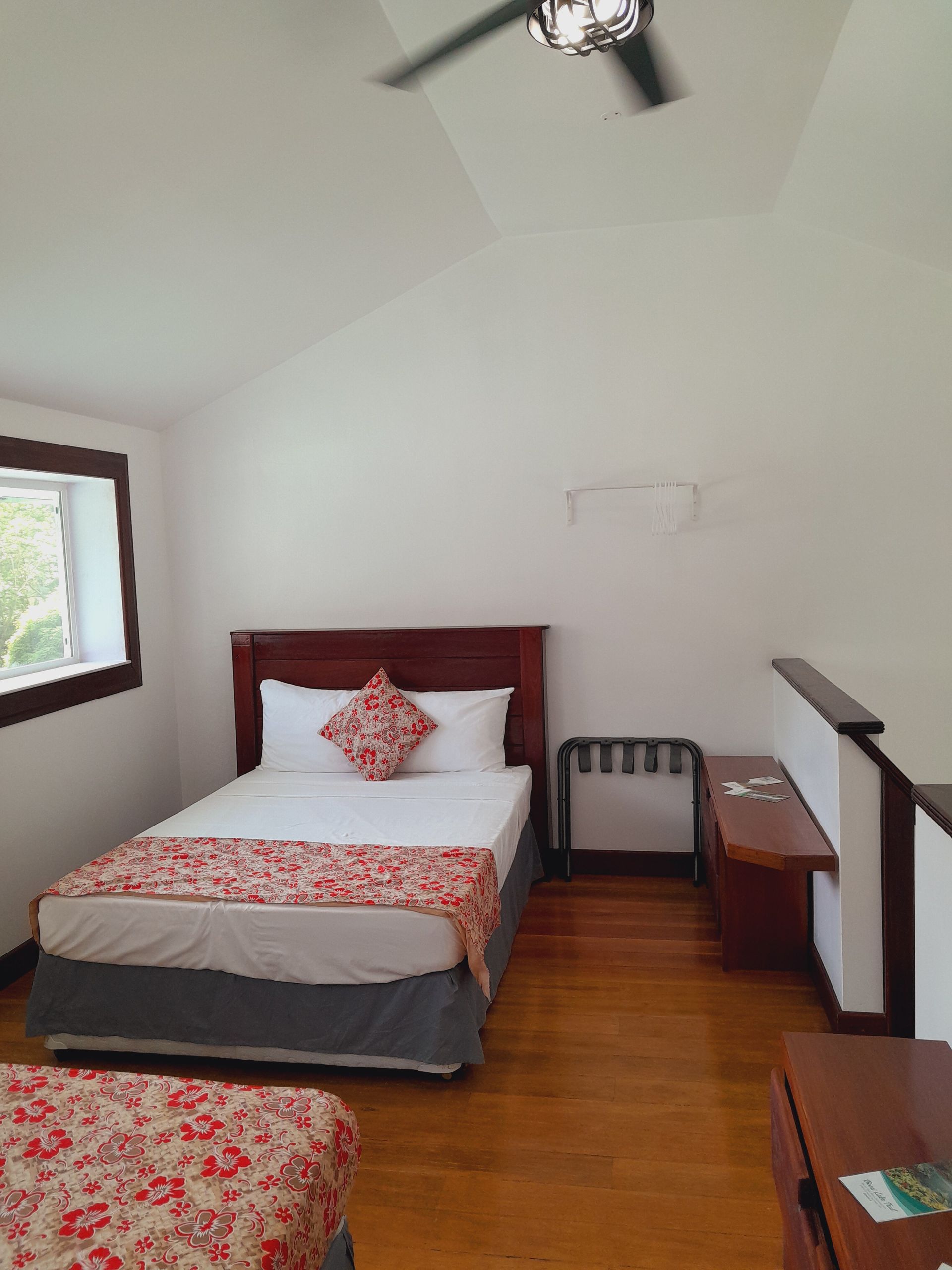 A bedroom with two beds and a ceiling fan.