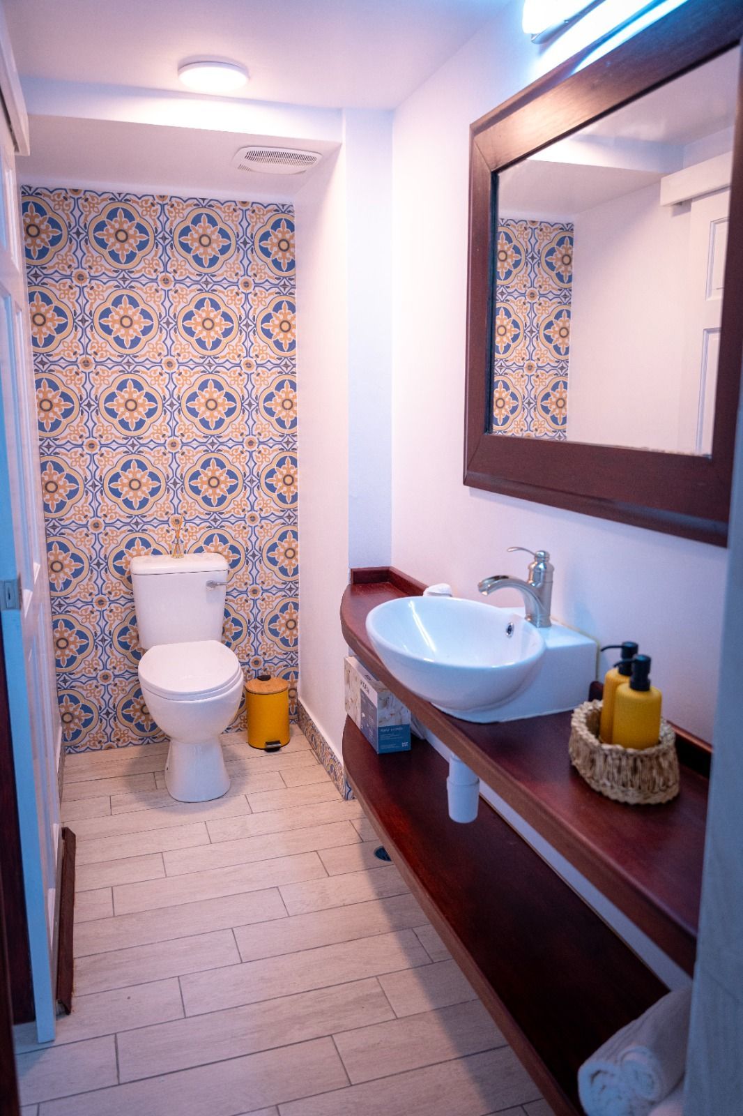 A bathroom with a toilet , sink and mirror.