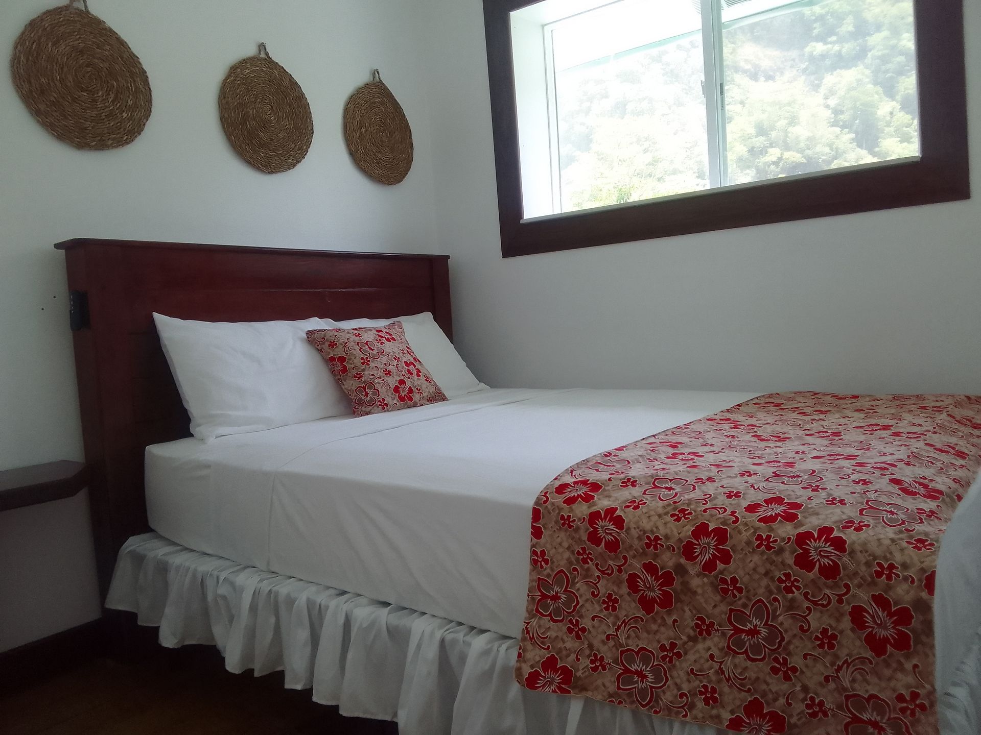 A bedroom with a bed and three baskets on the wall
