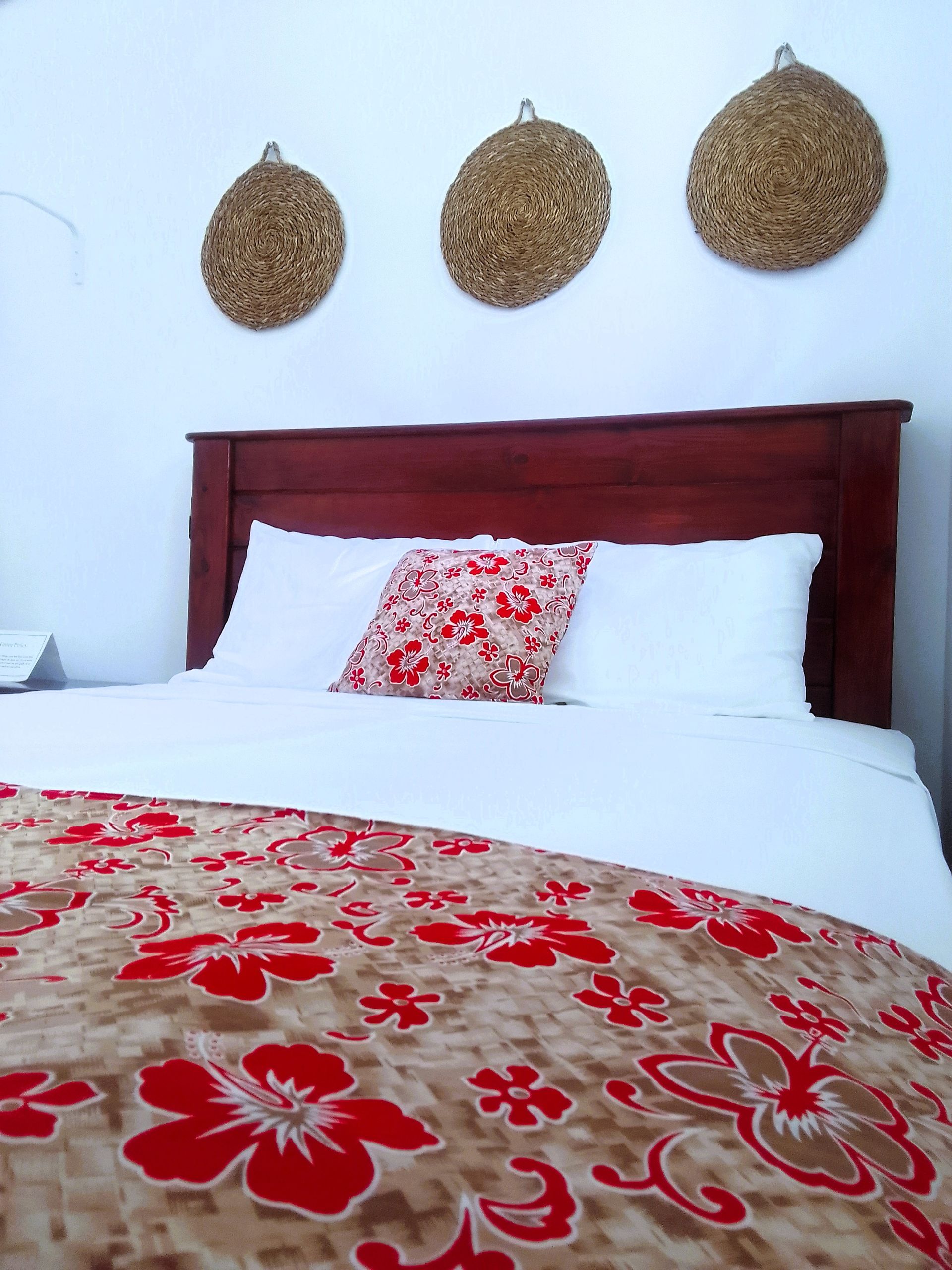 A bed with a floral blanket and pillows in a bedroom