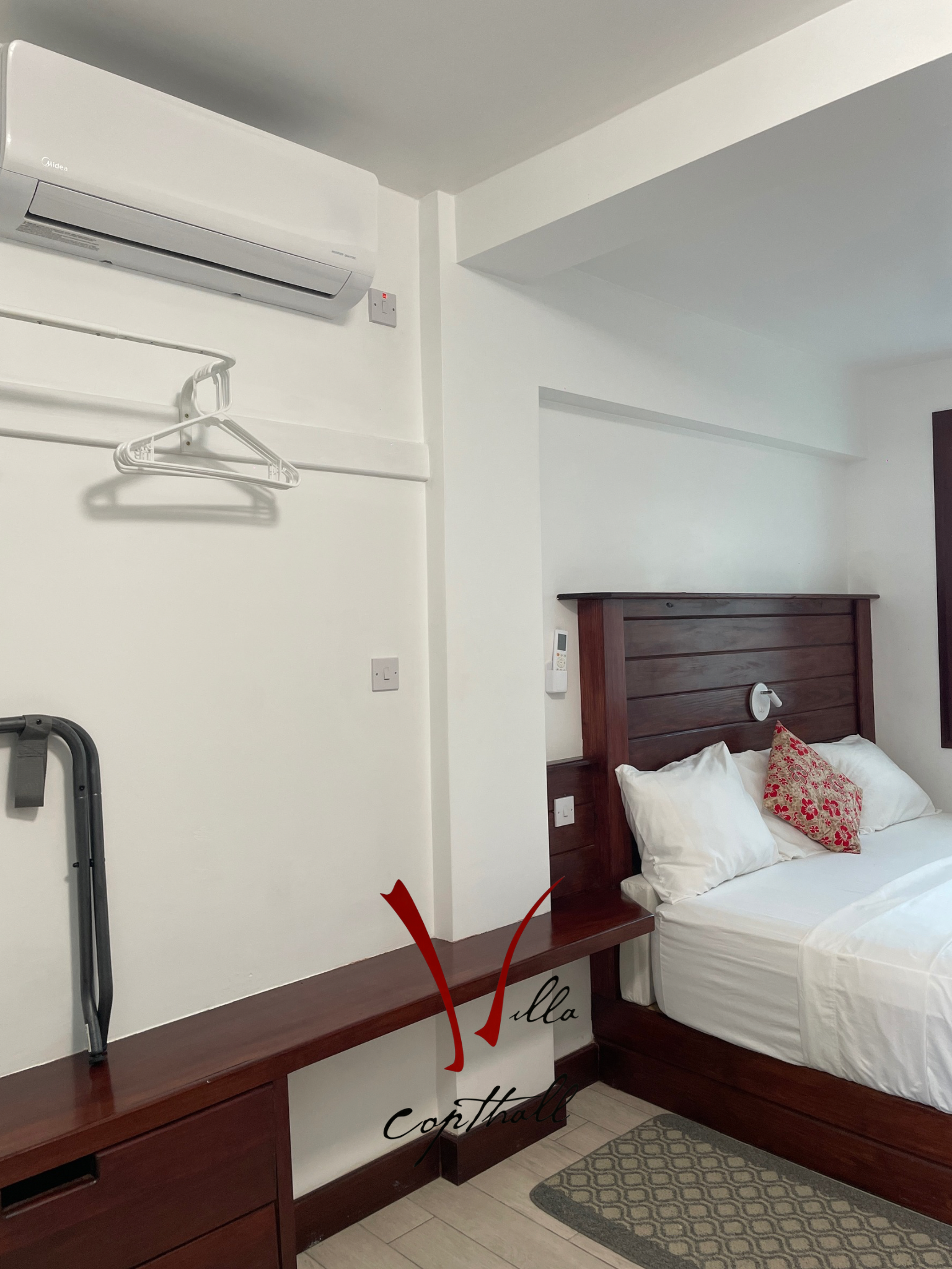A hotel room with a bed and a dresser