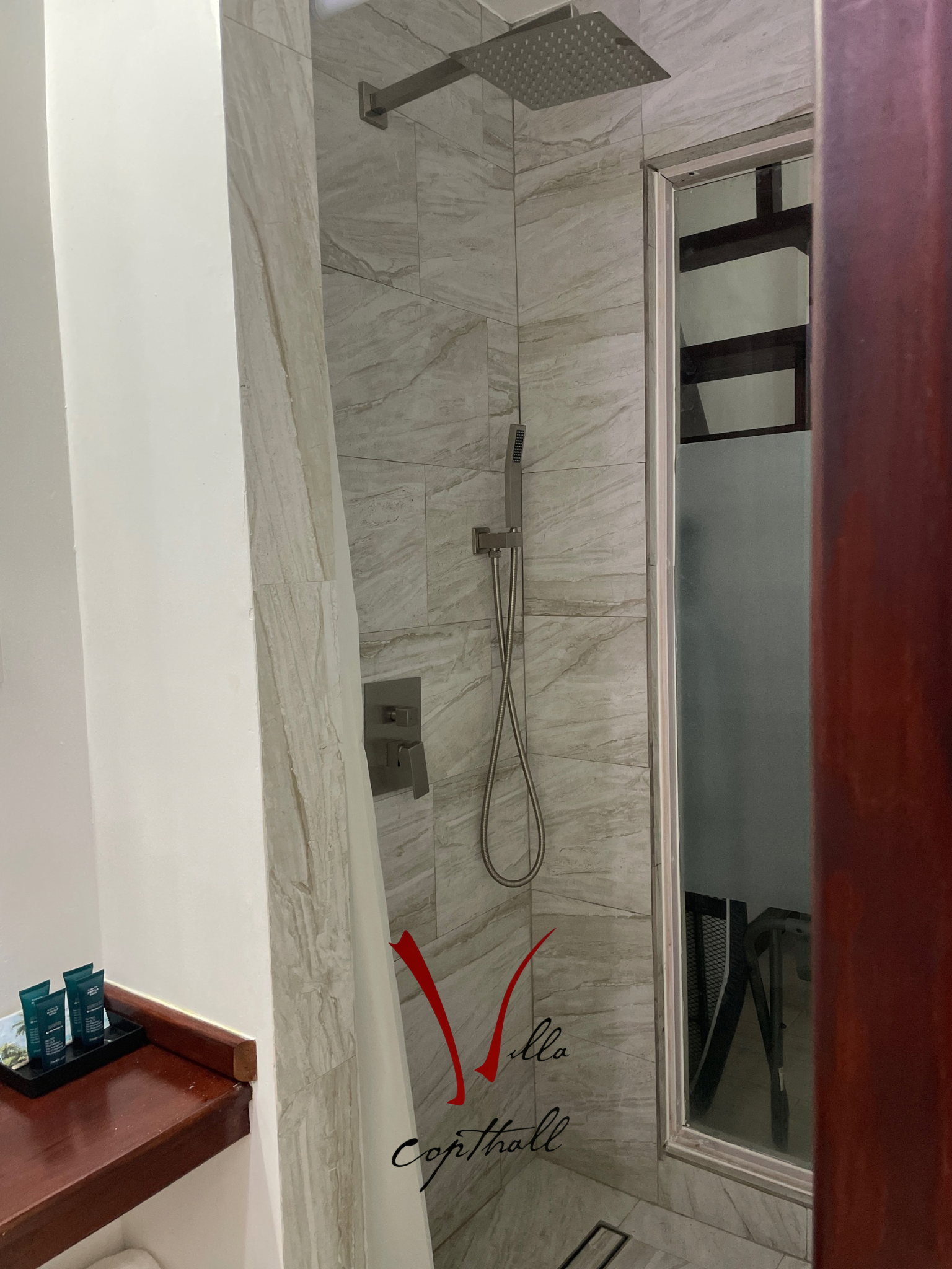A bathroom with a walk in shower and a mirror.