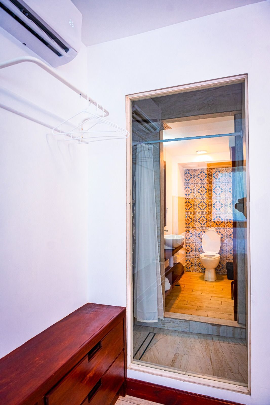 A bathroom with a toilet , sink , and mirror.