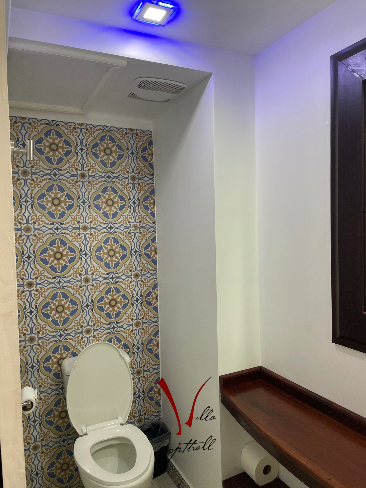 A bathroom with a toilet and a wooden bench.