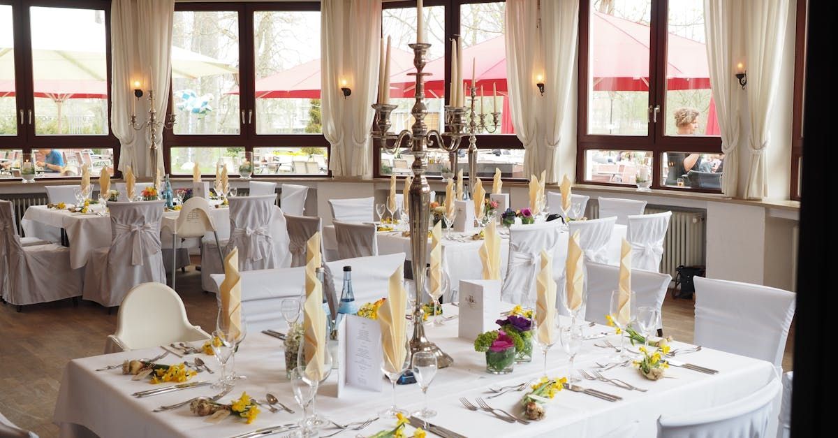 A large room with tables and chairs set up for a wedding reception.