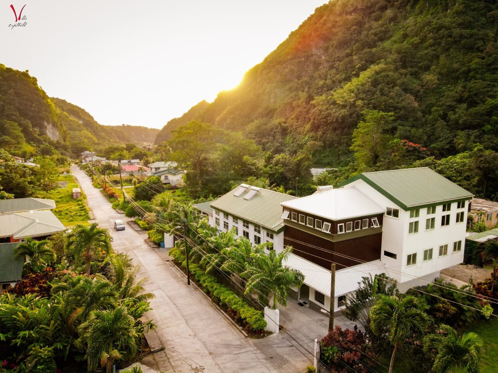 An aerial view of a house surrounded by trees and mountains