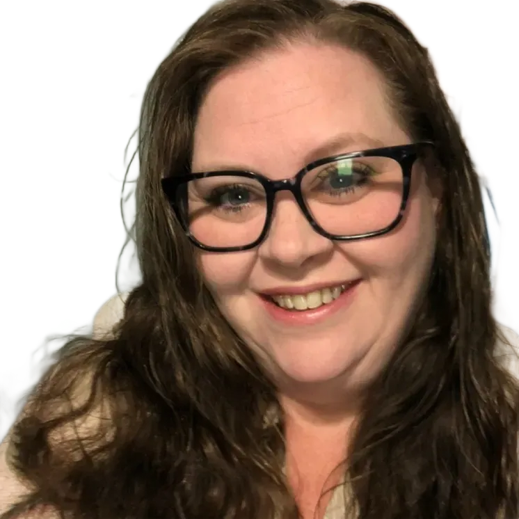 A person with long, dark, wavy hair wearing a teal top with a v-neckline and small gold hoop earrings, looking at camera.