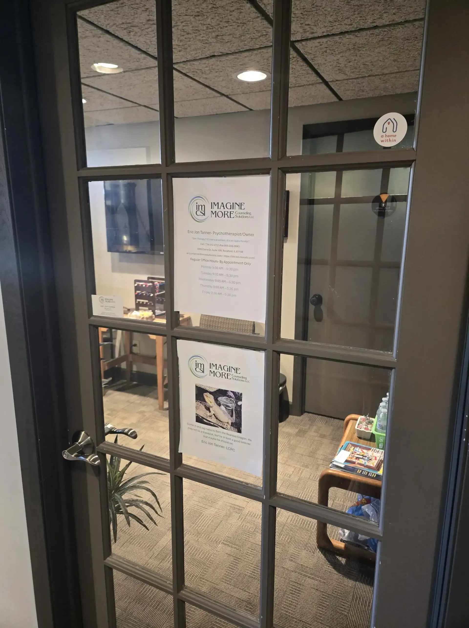 A glass-paneled office door with two informational fliers posted on the center panes, revealing a waiting room inside.