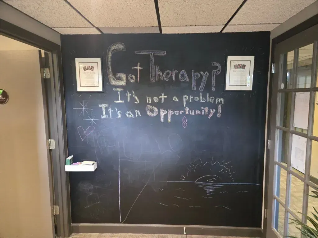A chalkboard on a wall reads, 
