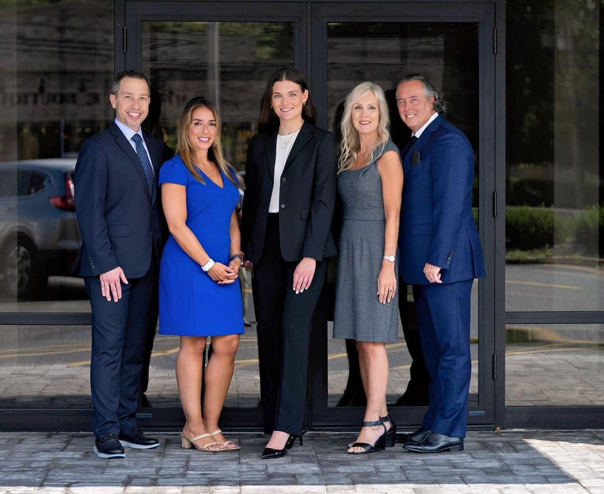 price law firm real estate lawyers posing for a picture in front of a building.
