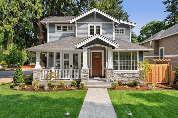 A large house with a lush green lawn and a walkway leading to it.