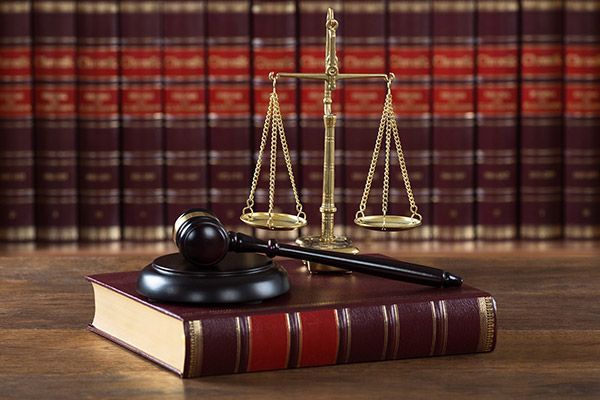 A judge 's gavel and scales of justice are sitting on top of a book.