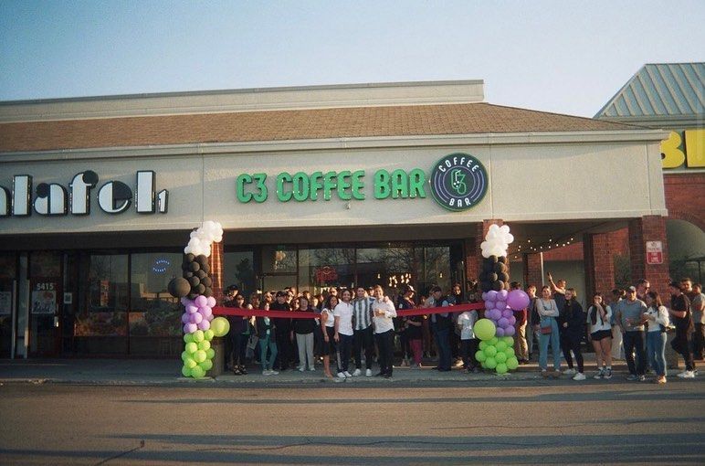 C3 Coffee Bar grand opening: crowd, ribbon cutting, balloons, store front, outdoor setting.