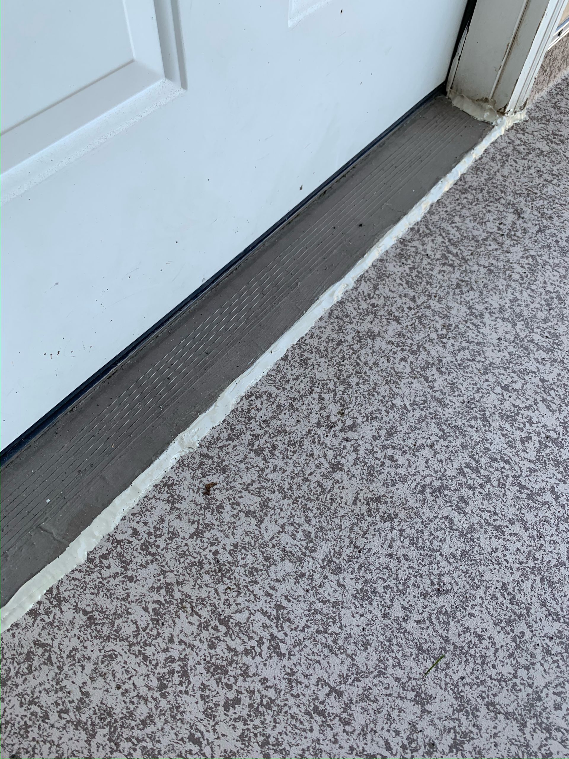 A carpeted floor with a white door in the background