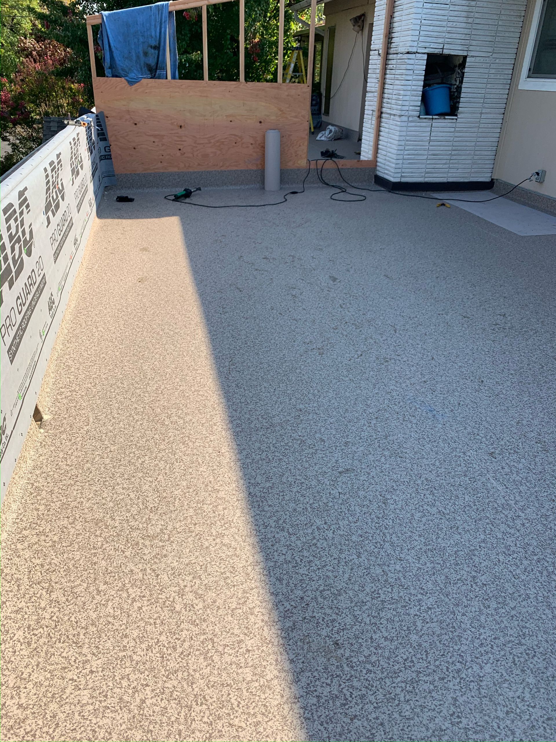 A concrete floor with a brick wall in the background