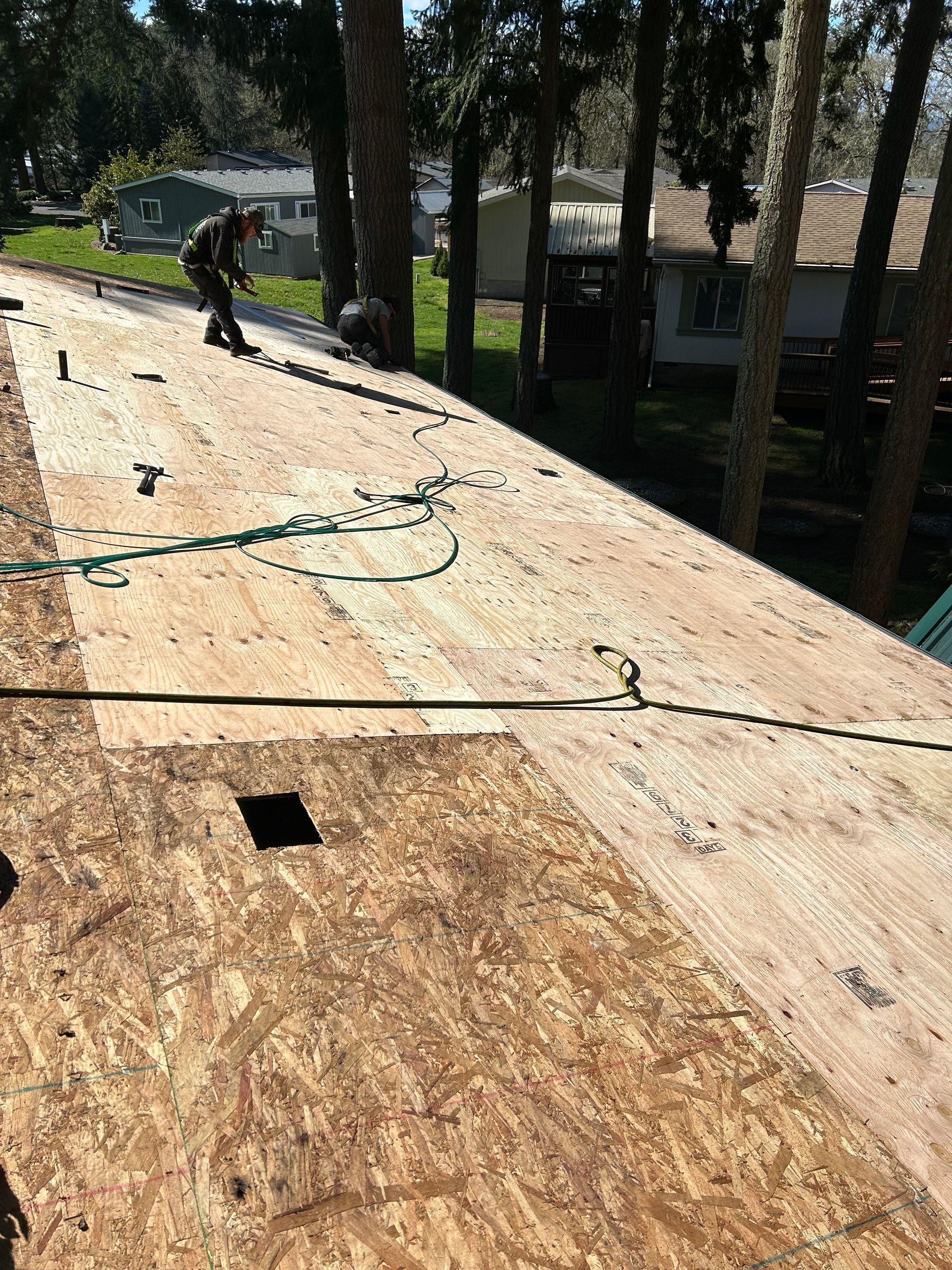 A man is working on the roof of a house.