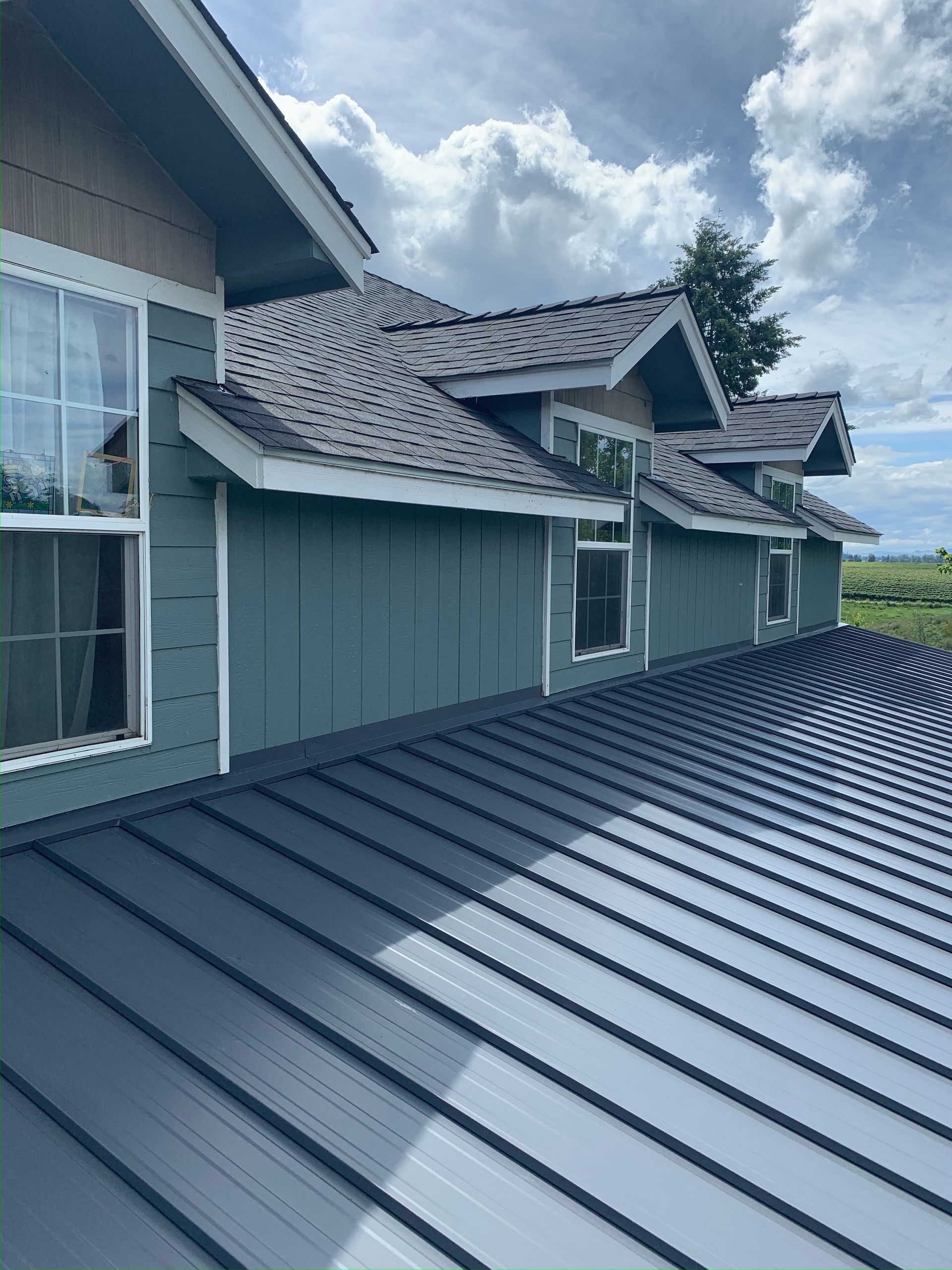 A house with a metal roof and blue siding