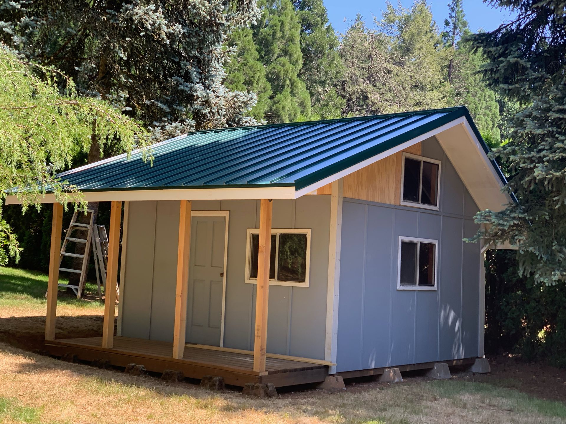 A small house with a green roof and a porch
