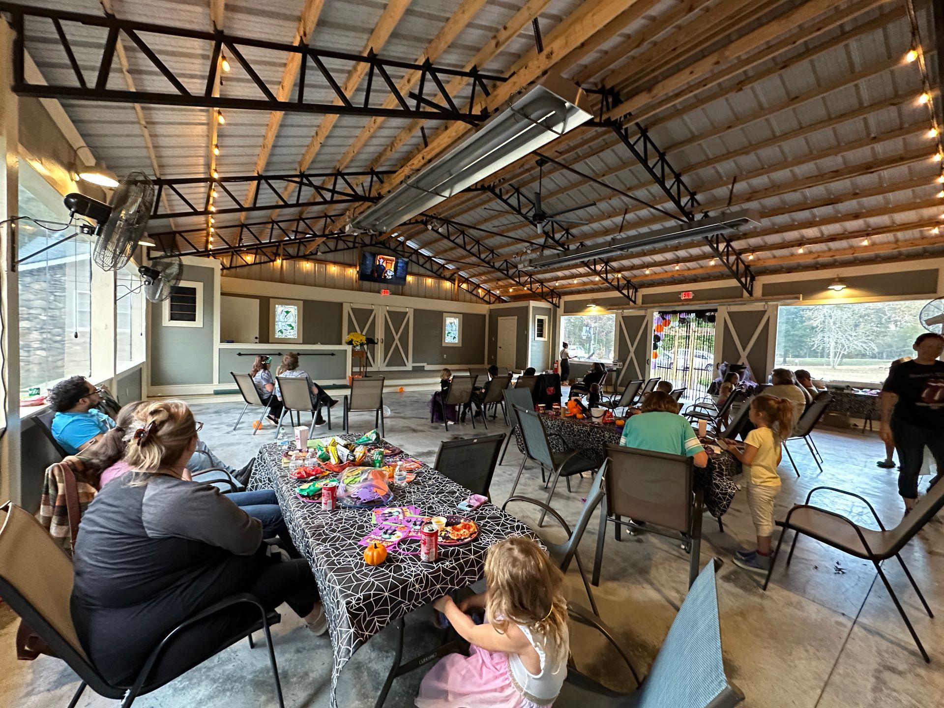 A group of people are sitting around a table in a large room.