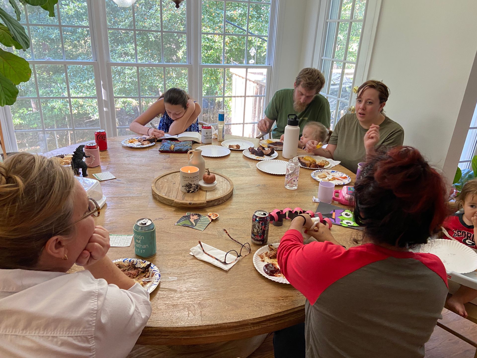 A group of people are sitting around a table eating food.