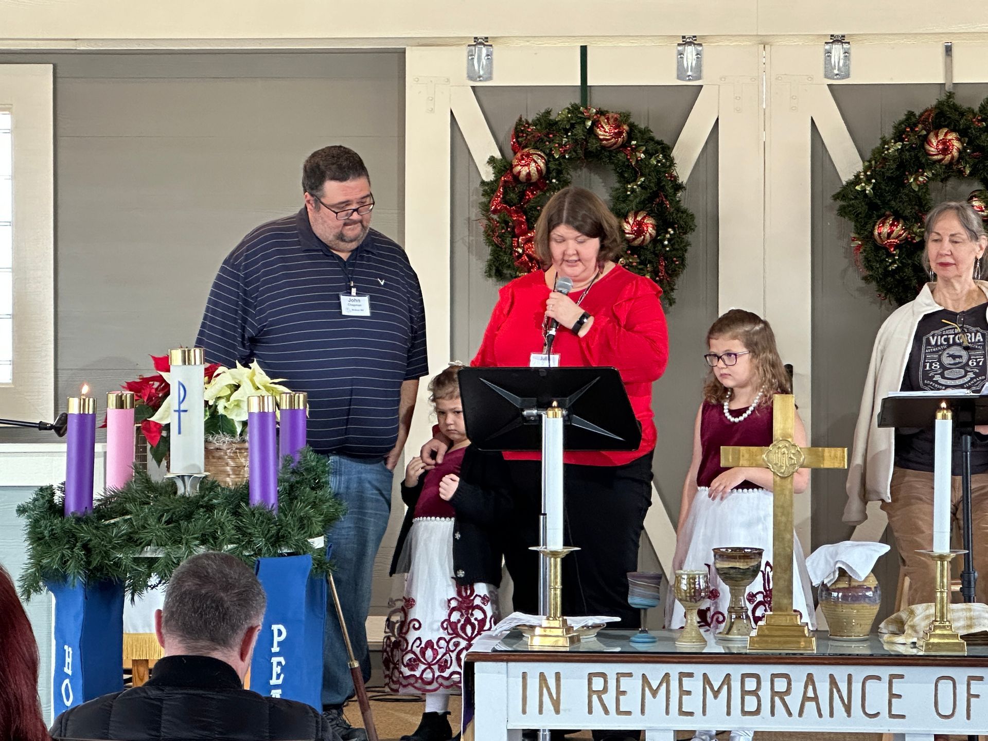 A group of people standing around the pulpit for an Advent reading 