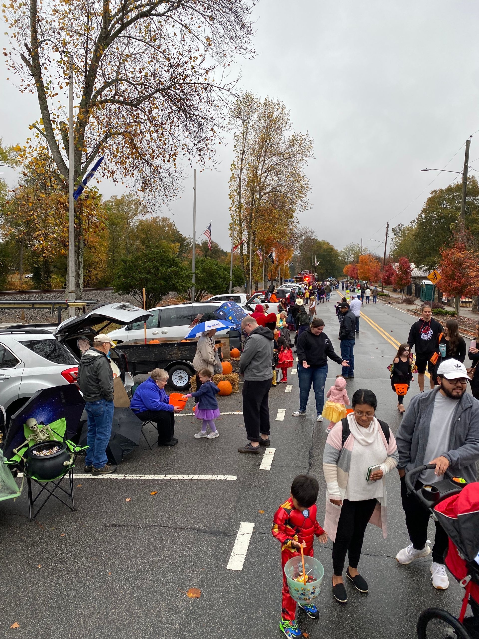 A group of people participating in a community wide Trunk or Treat event