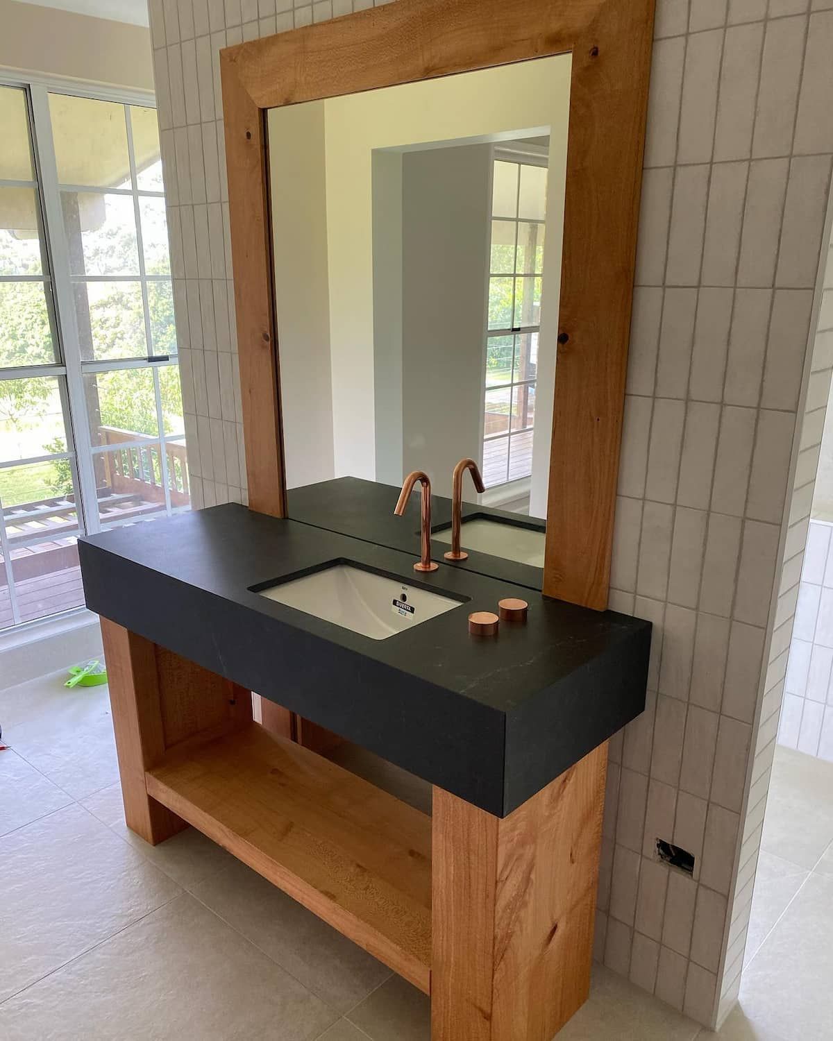 A Bathroom Sink With A Large Mirror Above It — Infinity Kitchens & Cabinets in Alstonville, NSW