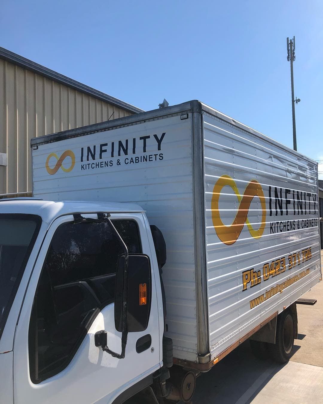 A White Infinity Truck Is Parked In Front Of A Building — Infinity Kitchens & Cabinets in Gold Coast, NSW